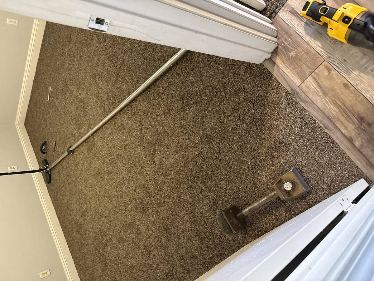 Carpet stretching tools laid out in a bedroom mid-job